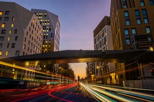 A long exposure shot of the Moulsecoomb campus at sundown, with trails of car headlights and taillights