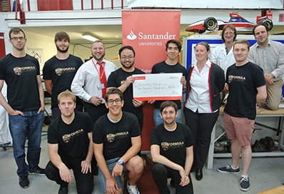 A group standing in front of the Santander logo