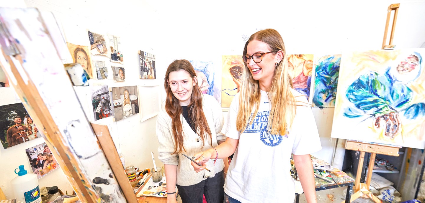 Two art students surrounded by paintings