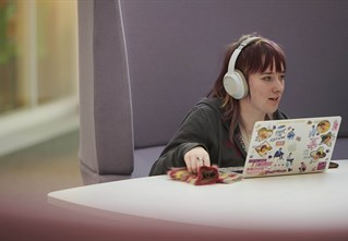 A student in headphones on a laptop