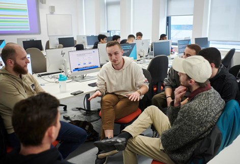 Group of students  discussing work in a computer room