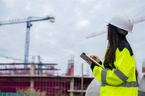 Site supervisor looking at cranes in distance