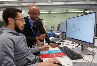Student and lecturer looking at computer in a BIM class