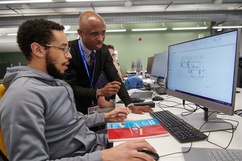 Student and lecturer looking at computer in a BIM class