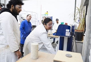 Two civil engineering students testing concrete in the lab