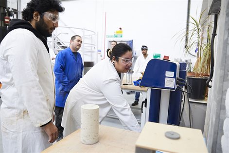 Two civil engineering students testing concrete in the lab