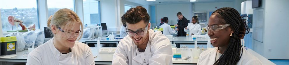 Three pharmacy students conducting an experiment in lab