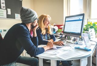 Two people looking at a computer