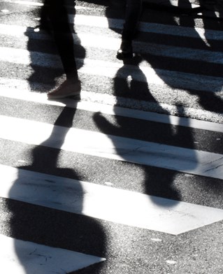 A zebra crossing with silhouette people approaching