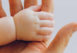 Baby hand gripping index finger of adult hand. Courtesy Pexels and Anna Shvets