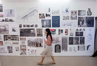 Student walking past architectural photos