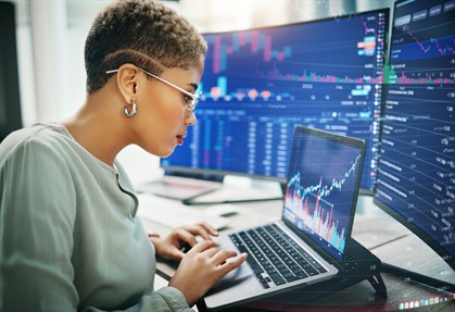 Female working from laptop looking at investment graphs