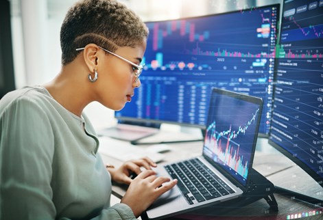 Female working from laptop looking at investment graphs