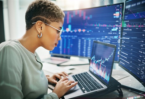 Female working from laptop looking at investment graphs