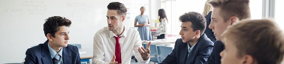 Male teacher sitting with students