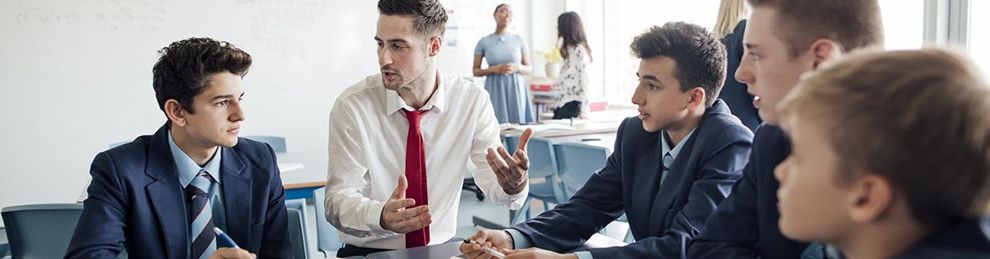 male teacher sitting with students