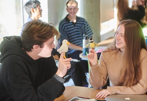 male and female student using finger puppets