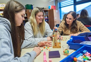 Group of teaching students with specialist maths equipment