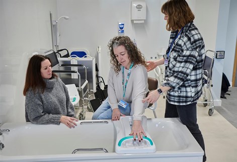 student being shown how to safely get into a bath