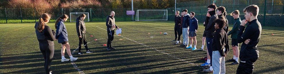 students being instructed on the all weather pitch