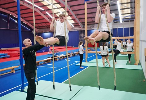 students climbing ropes in the sports hall