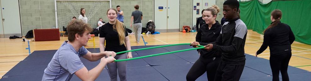 students pulling on a ring in the sports hall