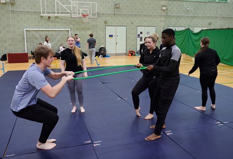 students pulling on a ring in the sports hall