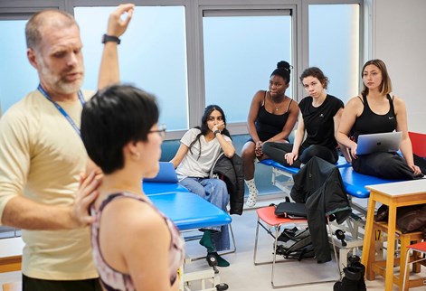 male lecturer doing a demo in the physiotherapy suite