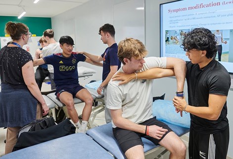 students practising physio on shoulders