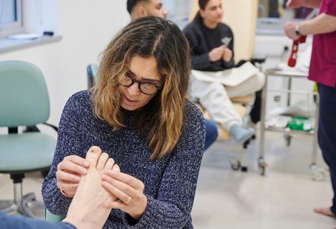 student manipulating a foot