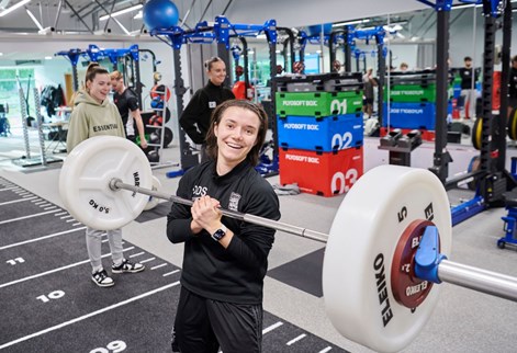 female student holding weights