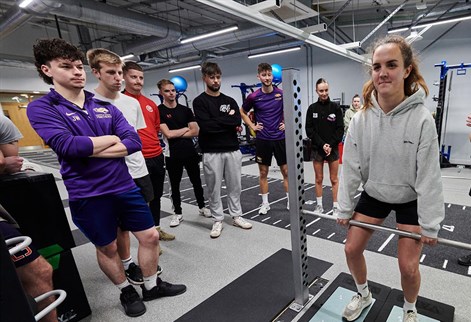 student doing a weight lifting test in the S&C suite