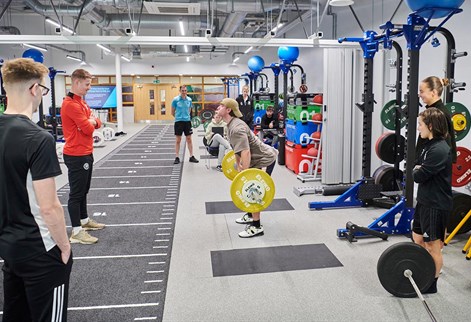 students liftin weights in the S&C suite