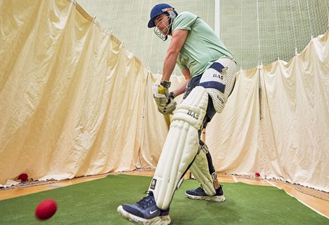 student playing cricket