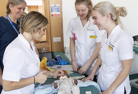 nursing students with a child mannequin