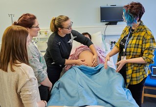 students with the birthing mannequin