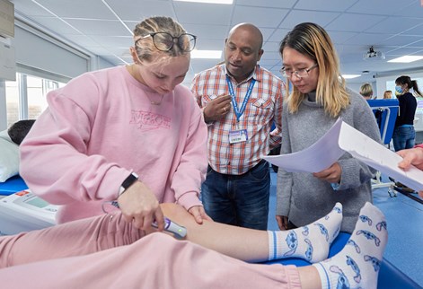 Group of students with lecturer in physio suite