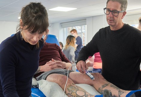 Physio students using an ultrasound on a patients knee