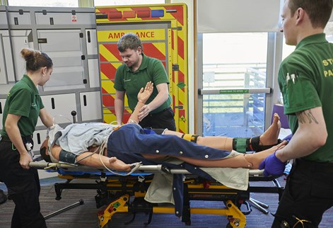 paramedic students putting a mannequin on a trolley