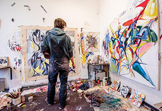 A student painting in an art studio