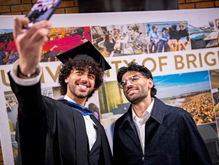 Graduating Brighton student taking a photo with family member 