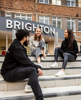 Students sitting on the steps outside Mithras House