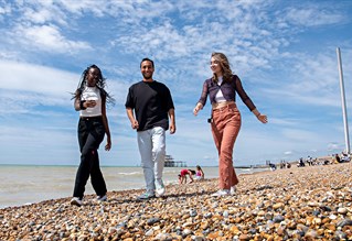 Students walking along Brighton beach