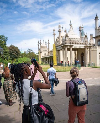 Student taking a photo of the outside of Brighton Pavilion