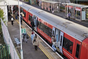 A Gatwick Express train at Falmer station, with the doors open and students departing