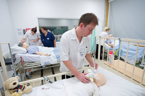 Trainee nurses practising on medical dolls