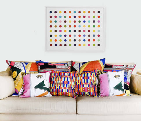 Coloured 1960s inspired cushions (by Freya Richmond) on a plain sofa 