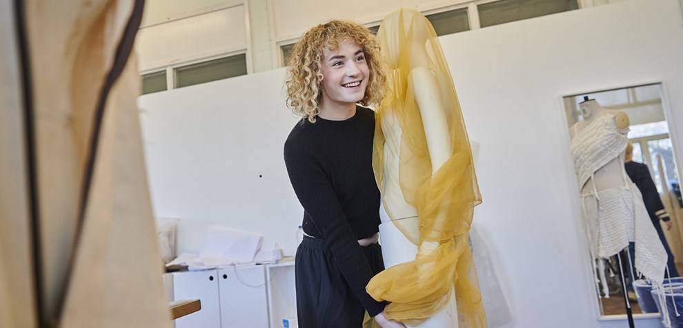 student wrapping fabric round a mannequin